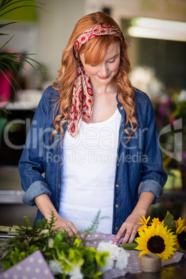 Female florist wrapping flower bouquet