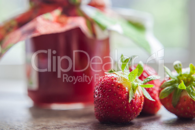 strawberry jam glass and berries in window light