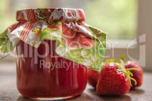 strawberry jam glass and berries in window light