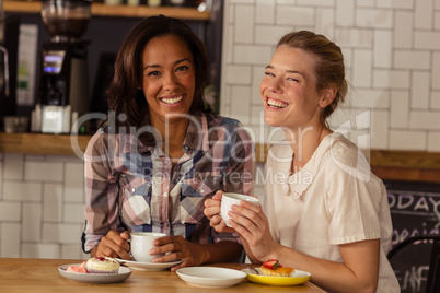 Female friends having fun while having coffee