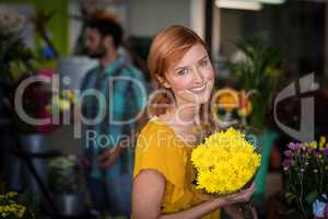 Portrait of female florist holding bouquet of flower