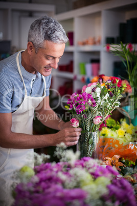 Smiling florist preparing a flower bouquet