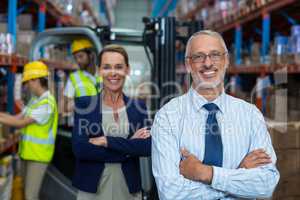 Portrait of warehouse manager and client smiling with arms crossed