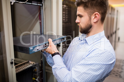 Technician removing server from rack mounted server