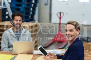 Portrait of warehouse managers using digital tablet and laptop