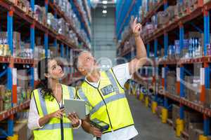 Warehouse workers discussing with digital tablet