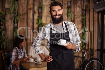 Portrait of waiter holding a cup of coffee