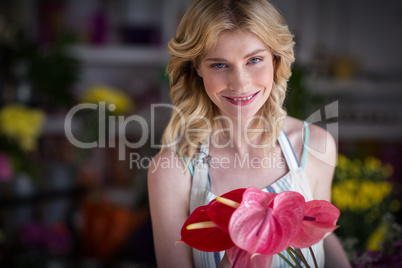 Female florist holding flowers in flower shop