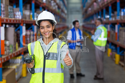 Female warehouse worker showing thumbs up sign