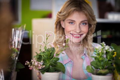 Portrait of happy female florist with flower pot