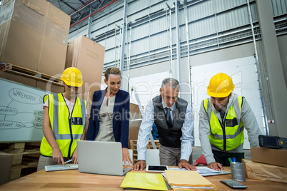 Warehouse workers and managers working in warehouse
