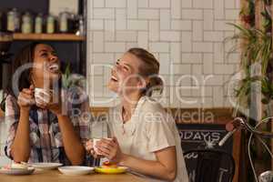 Female friends having fun while having coffee