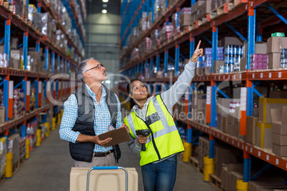 Warehouse workers discussing with clipboard while working