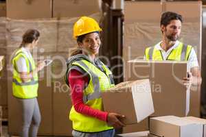 Portrait of warehouse worker carrying a cardboard box