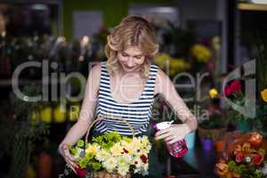 Female florists spraying water on flowers in flower shop