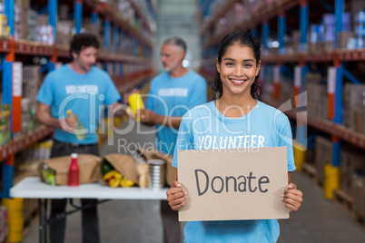 Portrait of happy volunteer holding sign boards with message