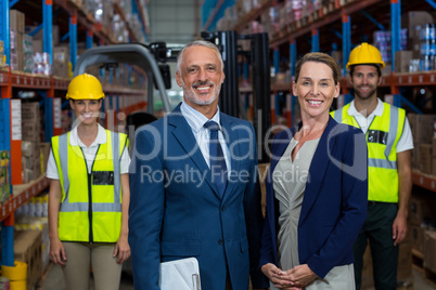 Portrait of warehouse manager standing with client