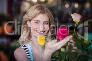 Smiling female florist arranging flower bouquet in vase at flower shop