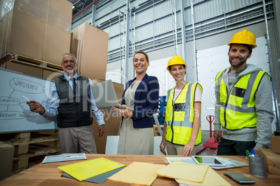 Warehouse workers and managers standing together in warehouse