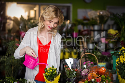 Female florist watering flowers