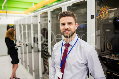 Smiling technician standing in a server room