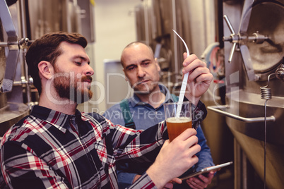 Owner examining beer in glass