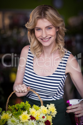 Female florists spraying water on flowers in flower shop