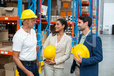 Happy warehouse managers and worker standing together