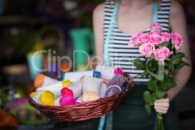 Female florist holding bunch of flower in flower shop