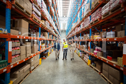 Warehouse team discussing while walking