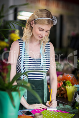 Female florist writing on a notepad