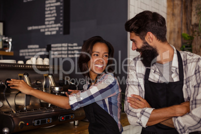 Waiter and waitress interacting while working in kitchen