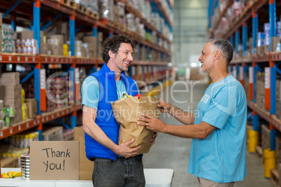 Portrait of happy volunteers holding a grocery bag