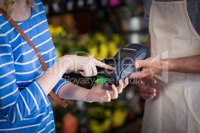 Woman making payment with her credit card to florist
