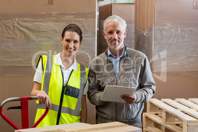 Portrait of warehouse manager and worker preparing a shipment