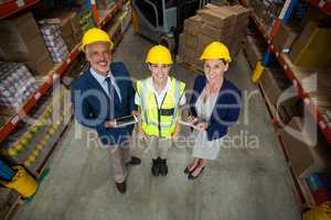 Warehouse manager standing with client and female worker