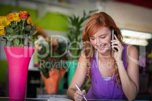 Female florist taking order on mobile phone
