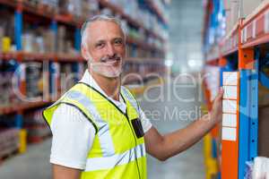 Portrait of warehouse worker standing near shelf