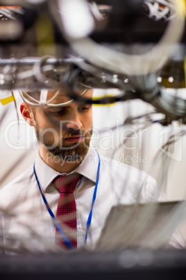 Technician using digital tablet while analyzing server