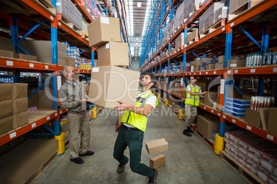 Worker losing his balance while carrying cardboard boxes