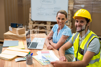 Warehouse managers and workers smiling in warehouse