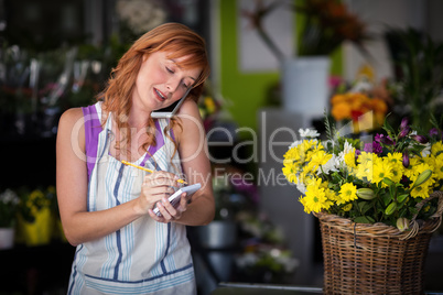 Female florist taking an order on mobile phone