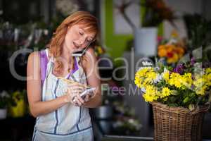 Female florist taking an order on mobile phone