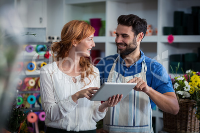 Couple using digital tablet and looking at each other