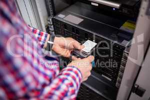 Technician inserting a hard disk drive into a blade server