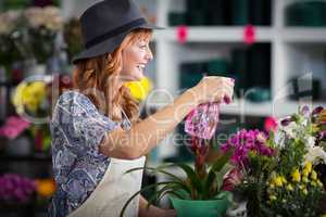 Florists spraying water on flowers in flower shop