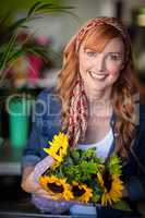 Smiling female florist holding bunch of flower