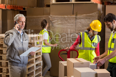 Warehouse manager and workers preparing a shipment