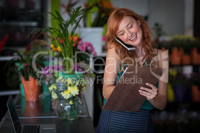 Female florist taking order on mobile phone