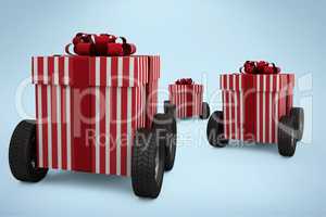 Composite image of striped red and white gift box on wheels